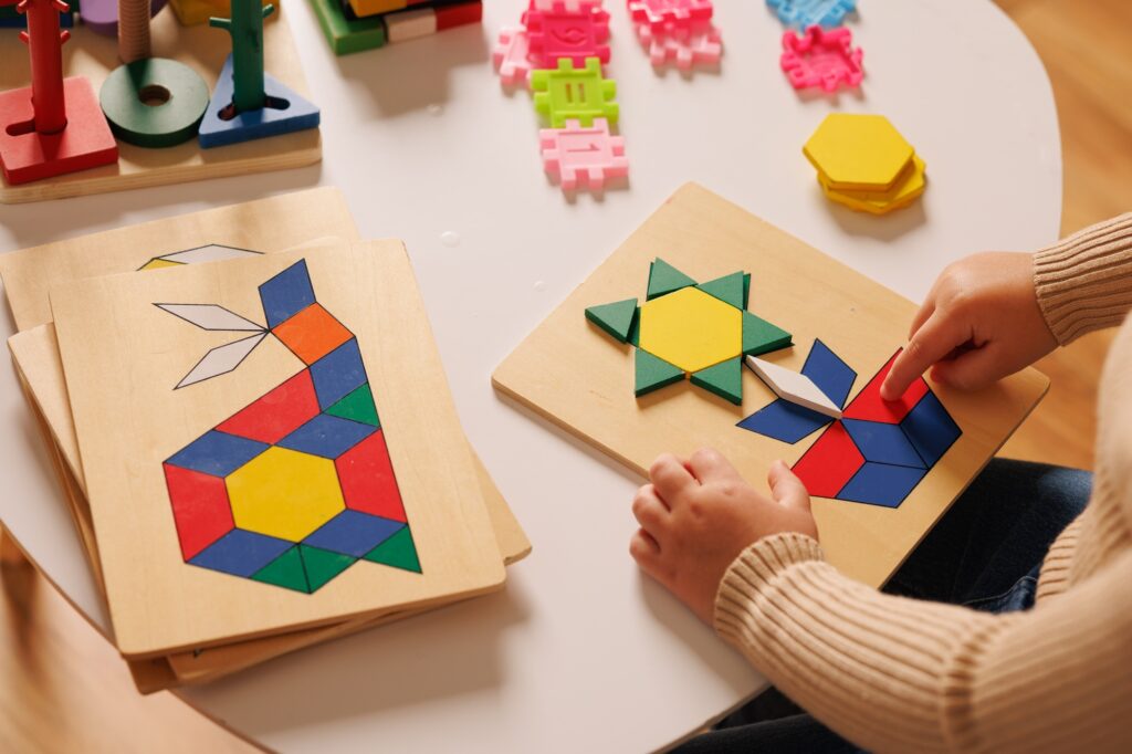 Close-up of children's hands playing with an educational multi-colored puzzle toy