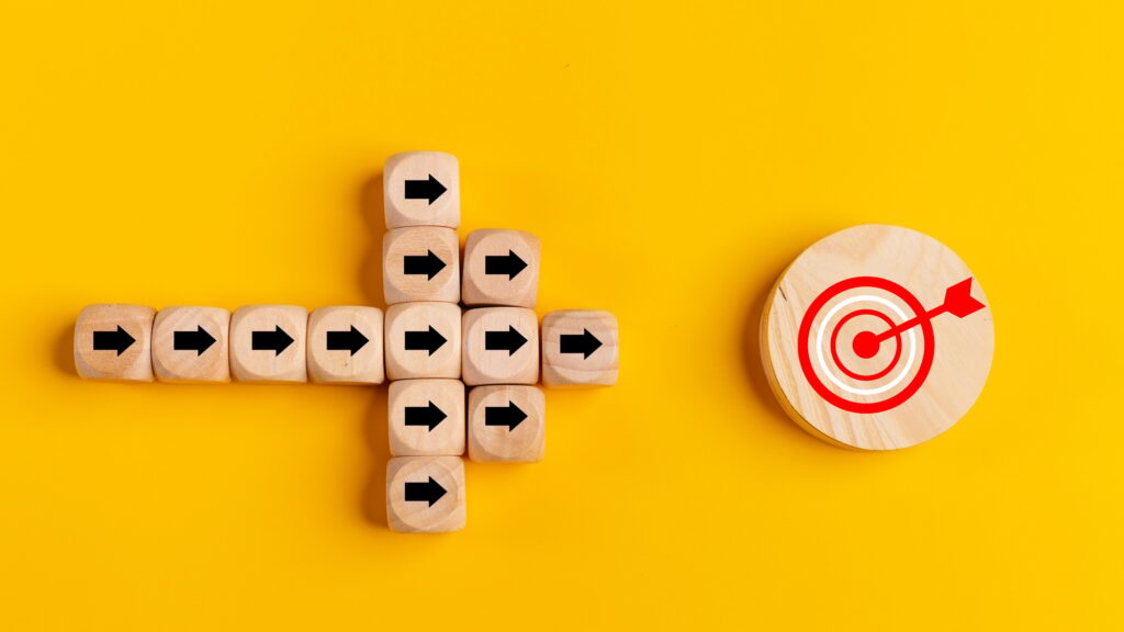 Concept of target marketing. Wooden blocks with arrow and target on blue background. Success concept