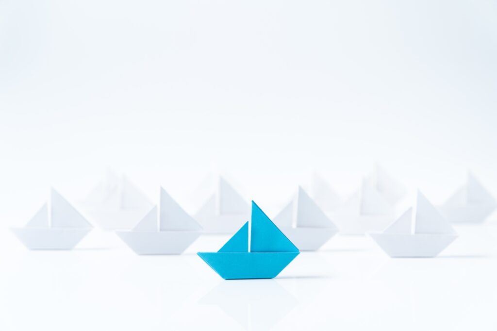 Leadership conceptual using blue paper ship