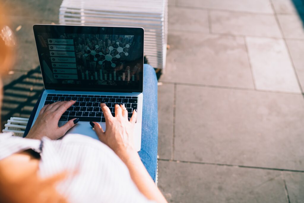 Woman sitting on street and using laptop