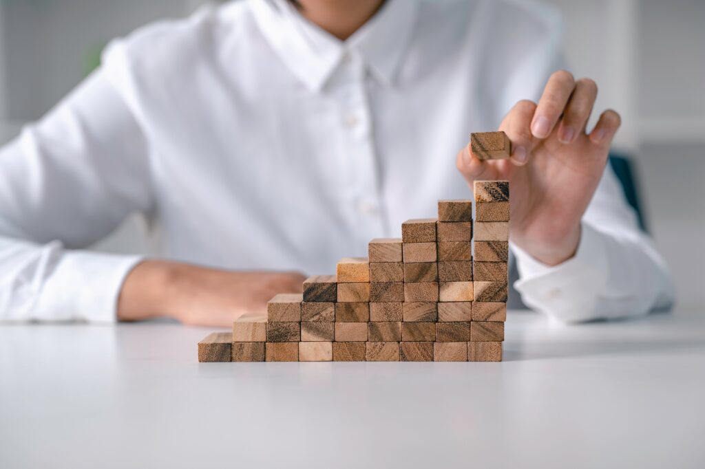 woman stacking wooden blocks in steps Investment Strategies Ideas Career Path Ladder to Business Gro